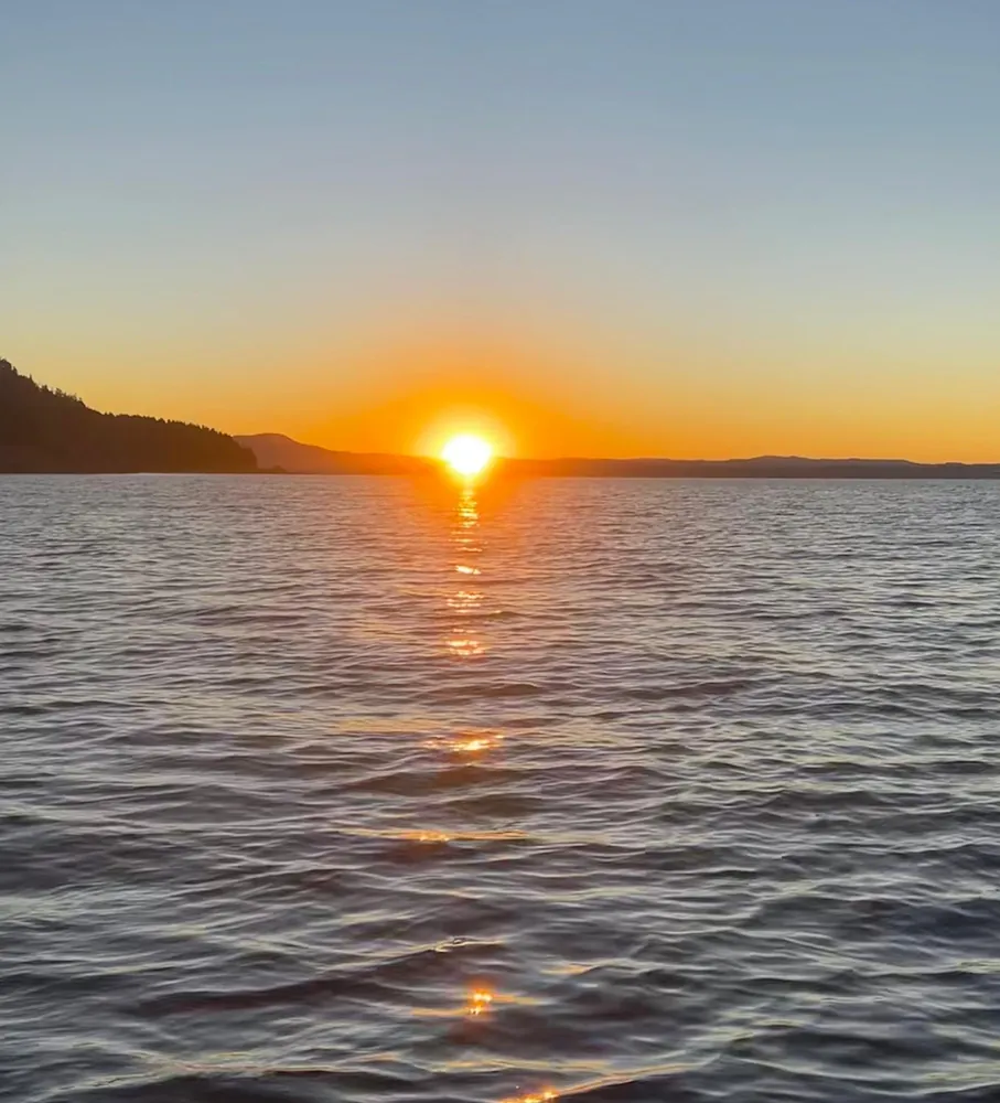Atardecer sobre el lago, con el reflejo del sol en el agua